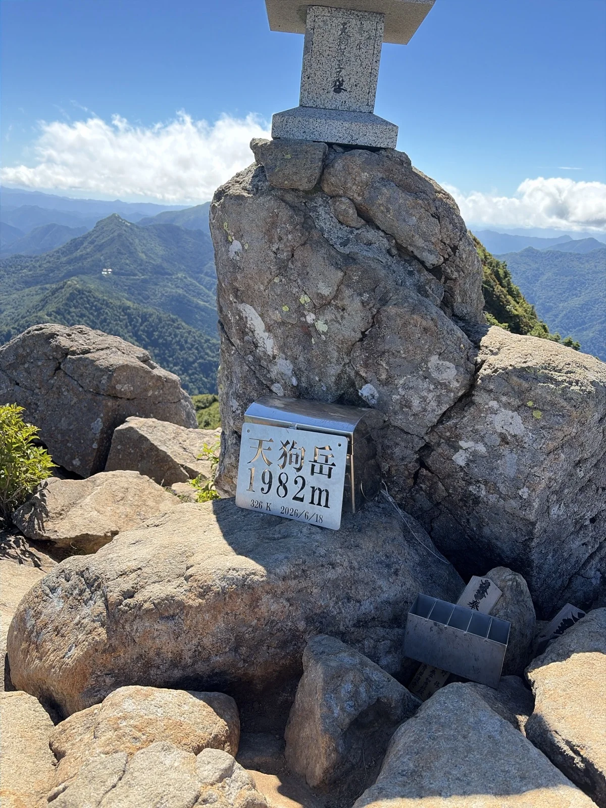 石鎚山の最高峰・天狗岳(標高1,982m)山頂の岩の上に祀られた小さな祠と、天狗岳1982mと刻まれた金属プレート