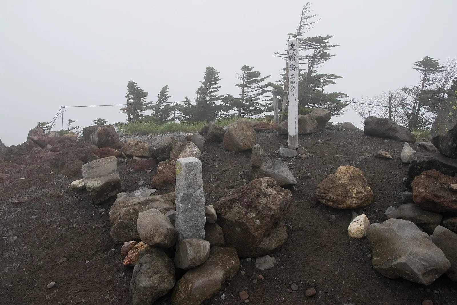 霧の中の北横岳山頂の岩と標柱