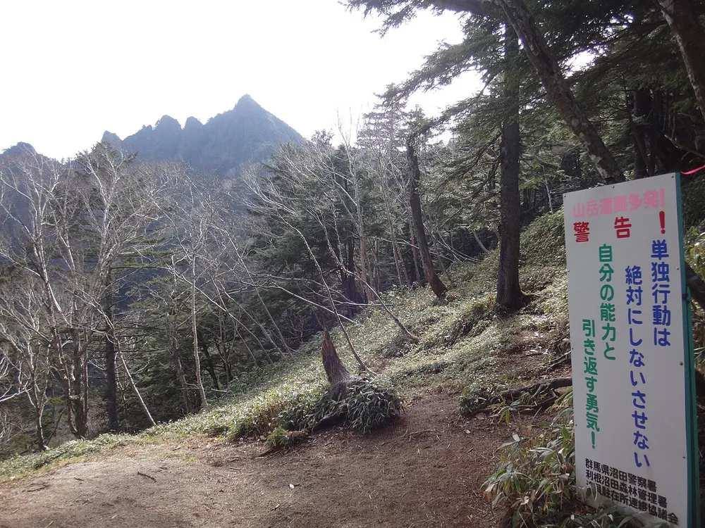 不動沢のコルから見た鋸山のギザギザした稜線。手前に注意を促す看板が立っている