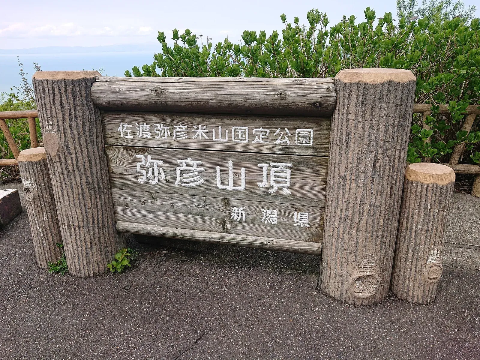 弥彦山頂の看板と、奥に広がる越後平野